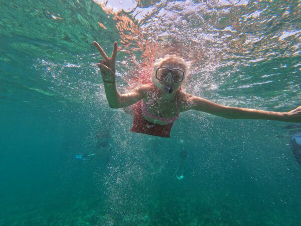 A woman swimming in the ocean under water.